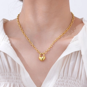 Détail du pendentif cadenas cœur en or 18 carats sur bracelet à gros maillons