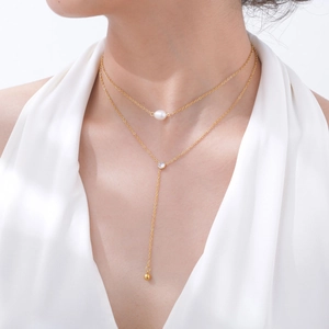 Detail of 18K gold double layer necklace with baroque pearl, zircon and long tassel pendant
