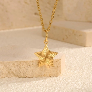 Detailaufnahme der goldenen Sternenkette mit spiralförmiger Textur und feiner O-Kette