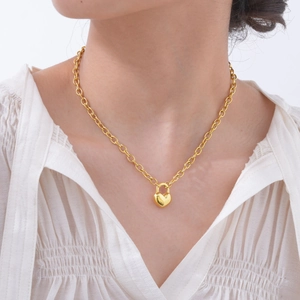Bracelet doré 18K avec pendentif cadenas en cœur porté par un mannequin