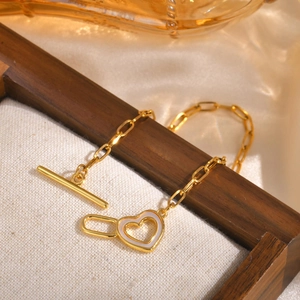 Macro view of gold heart pendant necklace with shell inlay and toggle clasp detail