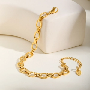 Gros plan du bracelet à gros maillons dorés 18K avec fermoir mousqueton et étiquette
