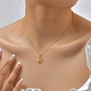 Elegante goldene Edelstahl-Sternhalskette mit strahliger Textur an weiblichem Modell