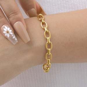 Gros plan d'un bracelet à maillons ovales épais en or 18 carats sur un poignet