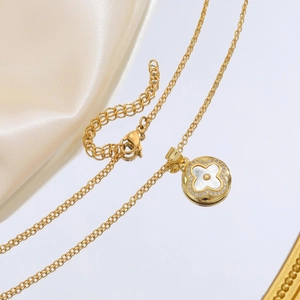 Détail du collier doré avec pendentif trèfle en nacre ronde et oxydes de zirconium