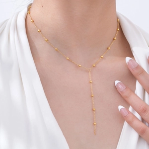 Elegant gold Y-shaped stainless steel necklace with bead accents shown on female model