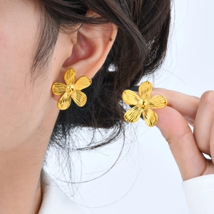 Detailansicht großer goldener Blumenohrstecker mit strahlend gebürsteter Blütenstruktur