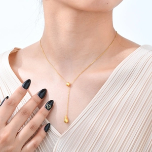 Detailaufnahme der 18K vergoldeten Y-Halskette mit Tropfenanhänger an einem Model