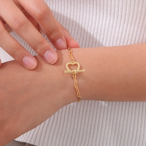 Detail of gold heart-shaped OT toggle clasp on stainless steel paperclip chain bracelet