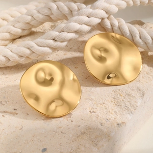 Exaggerated golden irregular round stud earrings with hammer texture on stone surface
