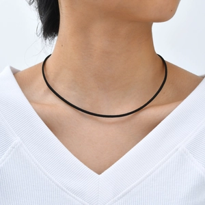 Ras de cou minimaliste en velours noir sur un mannequin portant un haut blanc à col en V