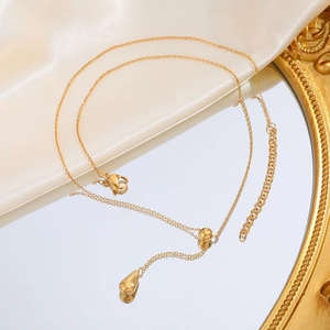 Elegante 18K vergoldete Edelstahl Y-Halskette mit Tropfenanhänger auf einem Spiegel