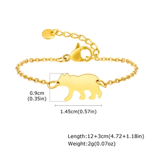 Détail d'un bracelet doré avec pendentif ours, fermoir mousqueton et chaîne d'extension