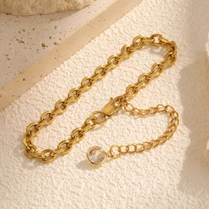 Detail der goldenen Gliederkette mit Karabinerverschluss und klarem Zirkon-Anhänger