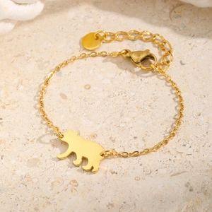Détail d'un bracelet en acier inoxydable doré avec pendentif ours et fermoir mousqueton