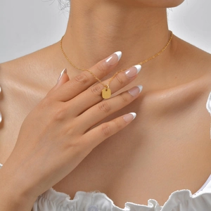 Close-up of geometric square pendant necklace in 18K gold plated finish on model