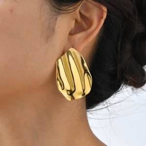 Close-up of a model wearing large 18K gold-plated irregular wavy stainless steel stud earrings
