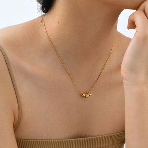 Elegant gold stainless steel necklace with three spiral-textured beads on a thin chain