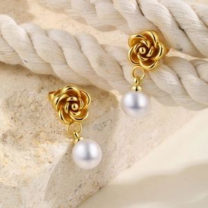 Detailed view of camellia pearl drop earrings featuring gold rose and white pearl detail
