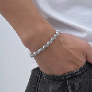 Détail d'un bracelet jonc Mobius minimaliste en acier inoxydable porté par un homme