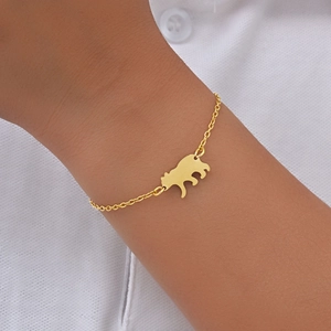Gros plan d'un bracelet ours minimaliste en acier inoxydable doré sur le poignet