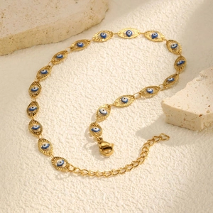 Detail of 18K gold evil eye anklet with blue enamel charms and adjustable lobster clasp
