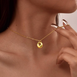Collier minimaliste plaqué or 18 carats avec pendentif géométrique porté par un mannequin