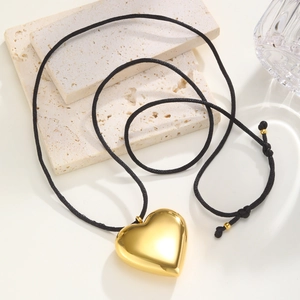 Polished hollow heart pendant on black adjustable cord necklace with gold beads