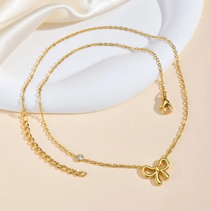 Collier élégant en acier inoxydable doré 18K avec nœud et zircon sur fond satiné blanc