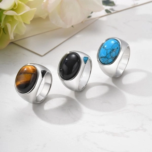 Detailed shot of three men's stainless steel rings featuring onyx, tiger eye and turquoise
