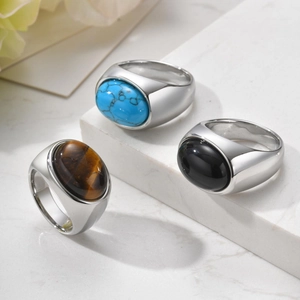 Detailed close-up of three vintage stainless steel rings with onyx and tiger eye stones