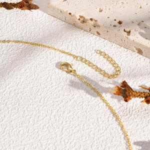 Detail of copper double-layered pearl necklace with golden lobster clasp and extender chain