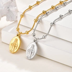 Gouden en zilveren Maria-hangers met kralen slangenketting op een marmeren voetstuk