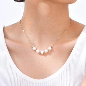 Close-up of double-layer gold plated copper necklace with five lustrous white pearls