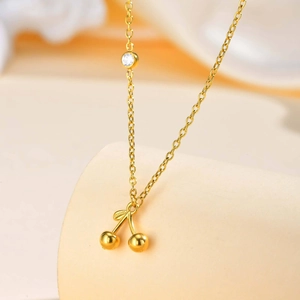 Detailed macro view of 18K gold-plated cherry pendant necklace with sparkling zircon stone