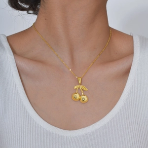Polished 18K gold stainless steel cherry pendant necklace worn by a fashion model