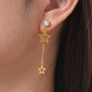 Dettaglio dell'orecchino a stella 18K con nappa e zircone sull'orecchio della modella