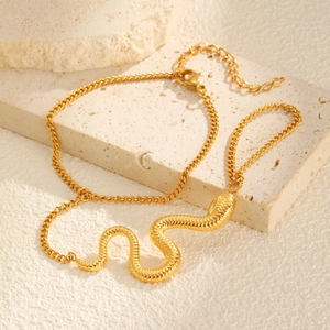 Macro detail of golden snake-shaped hand chain bracelet with scale textures on stone