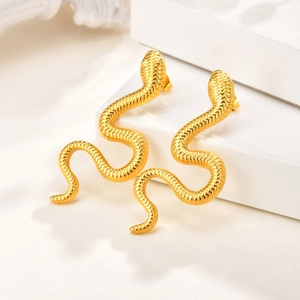 Detail of gold snake-shaped stud earrings with textured scale patterns on white stand