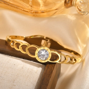 Gold stainless steel bangle featuring a roman numeral dial and sparkling zircon stone