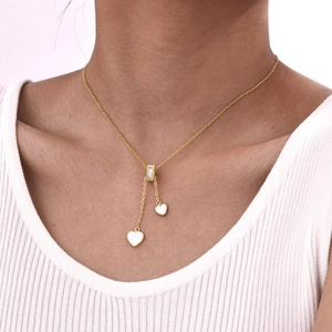Détail du collier avec pendentif en forme de cœur en nacre blanche et zircons