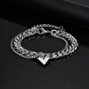 Detail of silver double-layer curb chain bracelet with polished triangle pendant