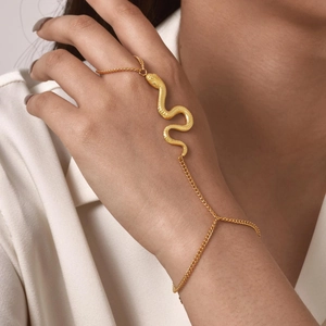 Detailed close-up of golden snake bracelet ring chain on hand with fine metal texture