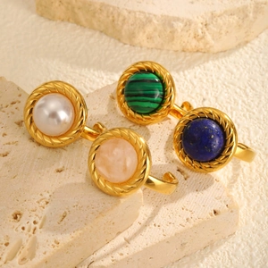 Lot de quatre bagues ouvertes en acier doré avec perles et pierres naturelles
