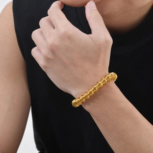 Close-up of golden stainless steel spring coil bracelet on wrist with industrial design