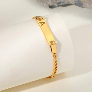 Detailed shot of gold plated Figaro bracelet featuring a hollow A letter nameplate