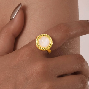 Détail macro d'une bague vintage en or 18 carats avec texture et pierre de marbre au doigt