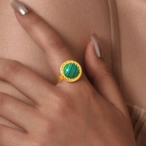 Détail de la bague en acier doré avec pierre de malachite et bordure torsadée