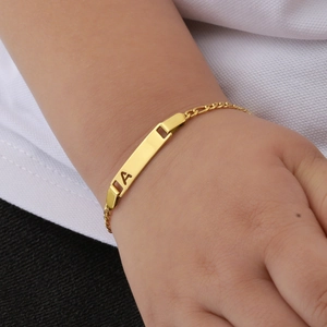 Close-up of gold plated baby ID bracelet with hollow letter A and Figaro chain