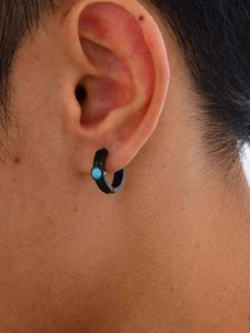 Close-up of man wearing black Celtic knot earring with a round turquoise stone inlay